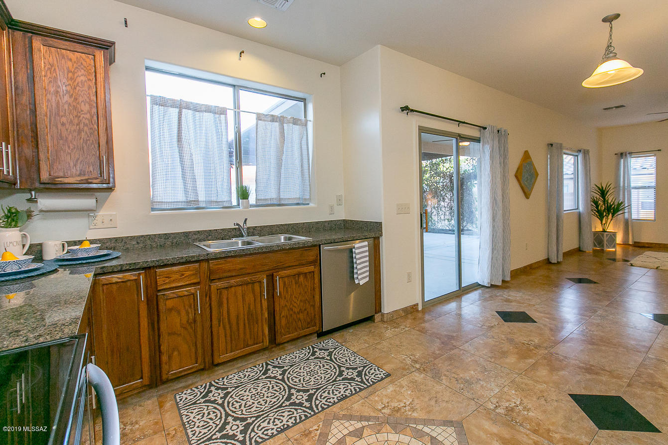 39103 Winners Circle Tucson, AZ 85739 - Photo 4 of 19 a large kitchen with granite countertop a sink and a stove top oven