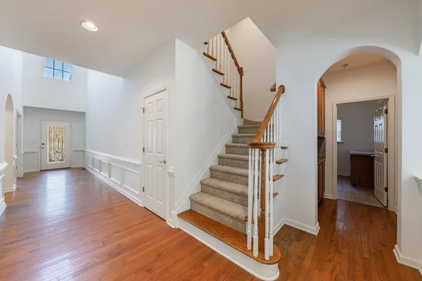 an empty room with wooden floor fireplace and windows