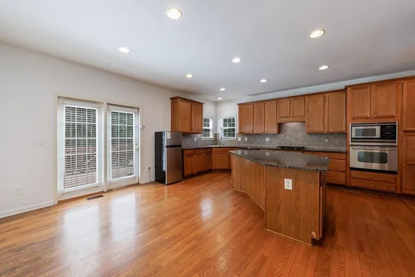 a kitchen with stainless steel appliances granite countertop a sink a stove a refrigerator and cabinets