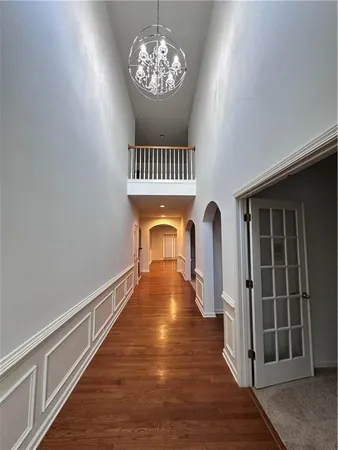 a view of a hallway with wooden floor and staircase
