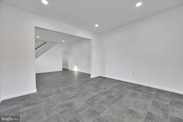 an empty room with stairs and windows