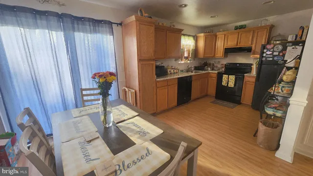 a kitchen with granite countertop wooden floors a refrigerator and a stove top oven