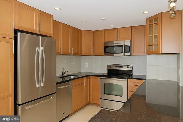 a kitchen with a sink a microwave a refrigerator and cabinets