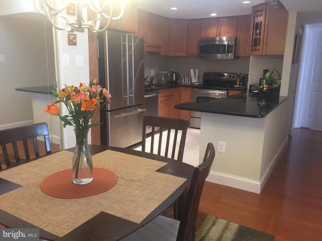 a kitchen with dining table stainless steel appliances and a refrigerator