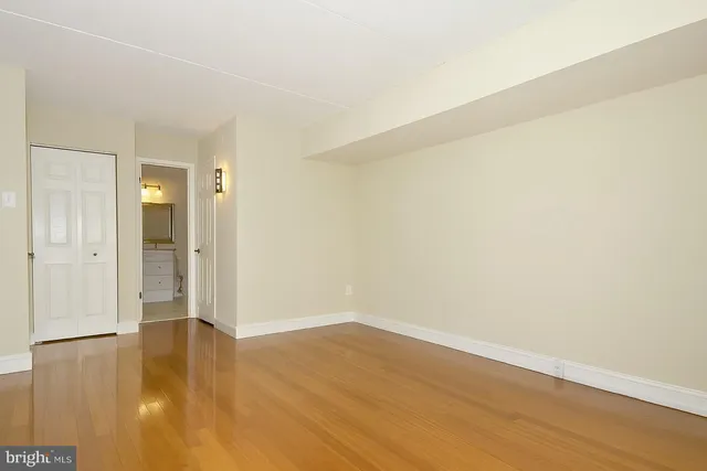 a view of an empty room with wooden floor