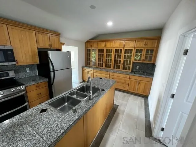 26945 Valley Center Road Valley Center, CA 92082 - Photo 3 of 17 a kitchen with granite countertop a refrigerator a stove top oven a sink and dishwasher