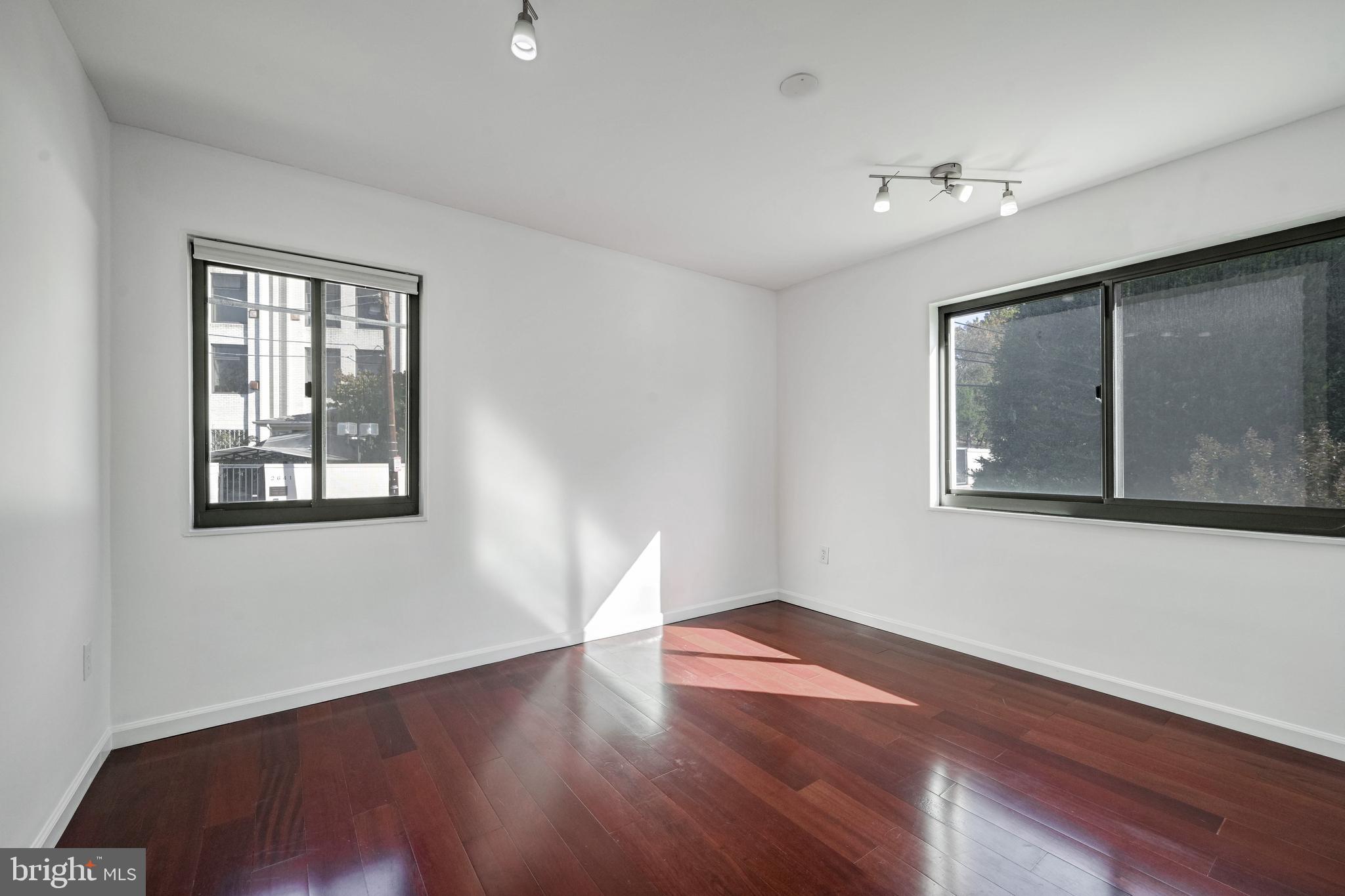 2610 Tunlaw Road Northwest, Unit 104 Washington, DC 20007 - Photo 12 of 20 a view of an empty room with wooden floor and a window