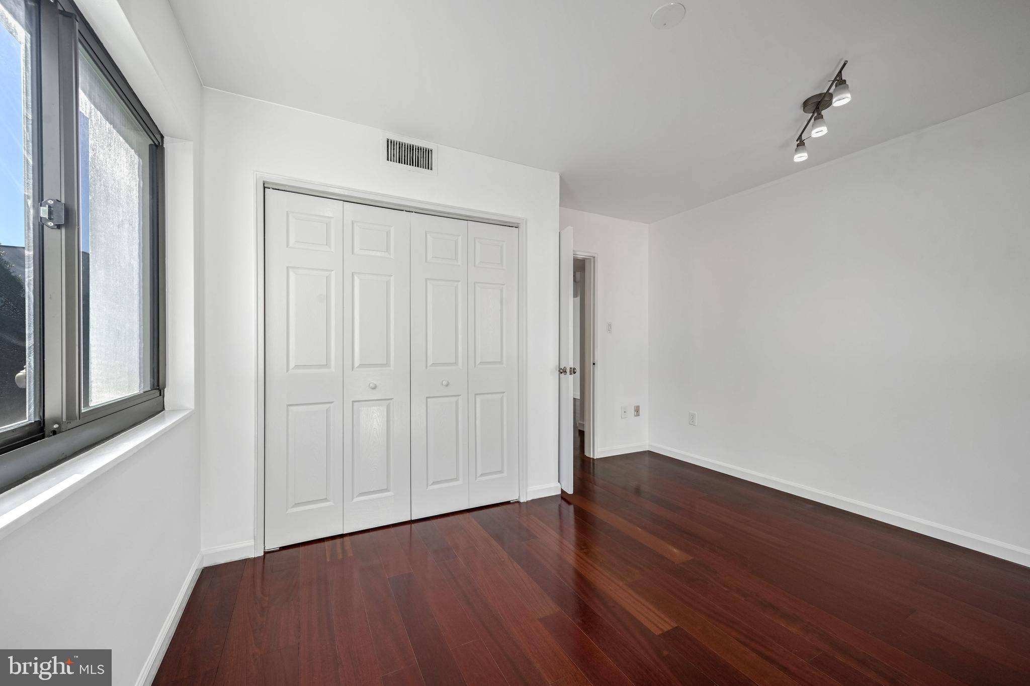 2610 Tunlaw Road Northwest, Unit 104 Washington, DC 20007 - Photo 13 of 20 a view of an empty room with wooden floor
