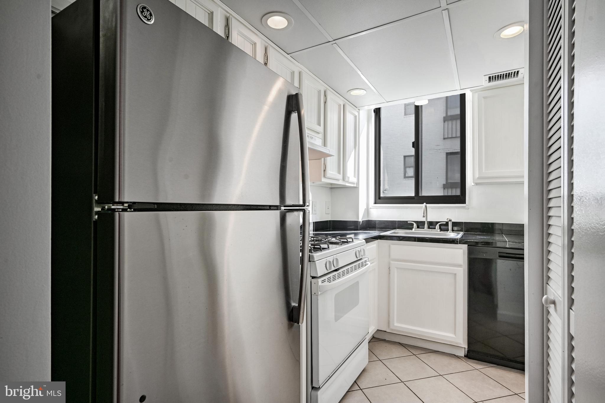 2610 Tunlaw Road Northwest, Unit 104 Washington, DC 20007 - Photo 14 of 20 a kitchen with white cabinets and white appliances