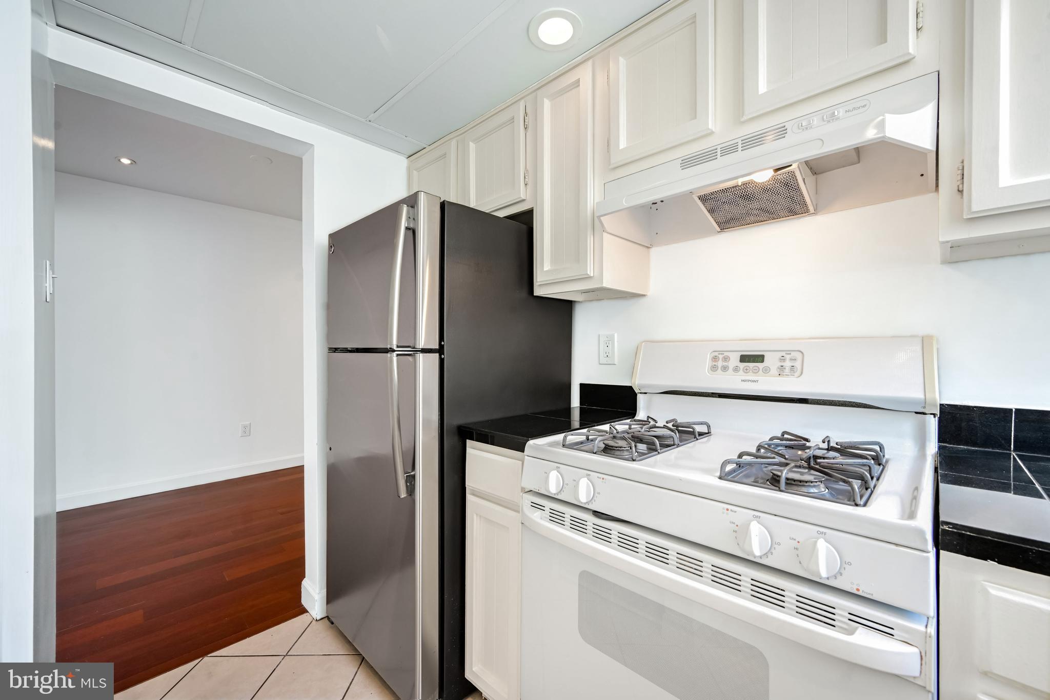2610 Tunlaw Road Northwest, Unit 104 Washington, DC 20007 - Photo 16 of 20 a kitchen with appliances and cabinets