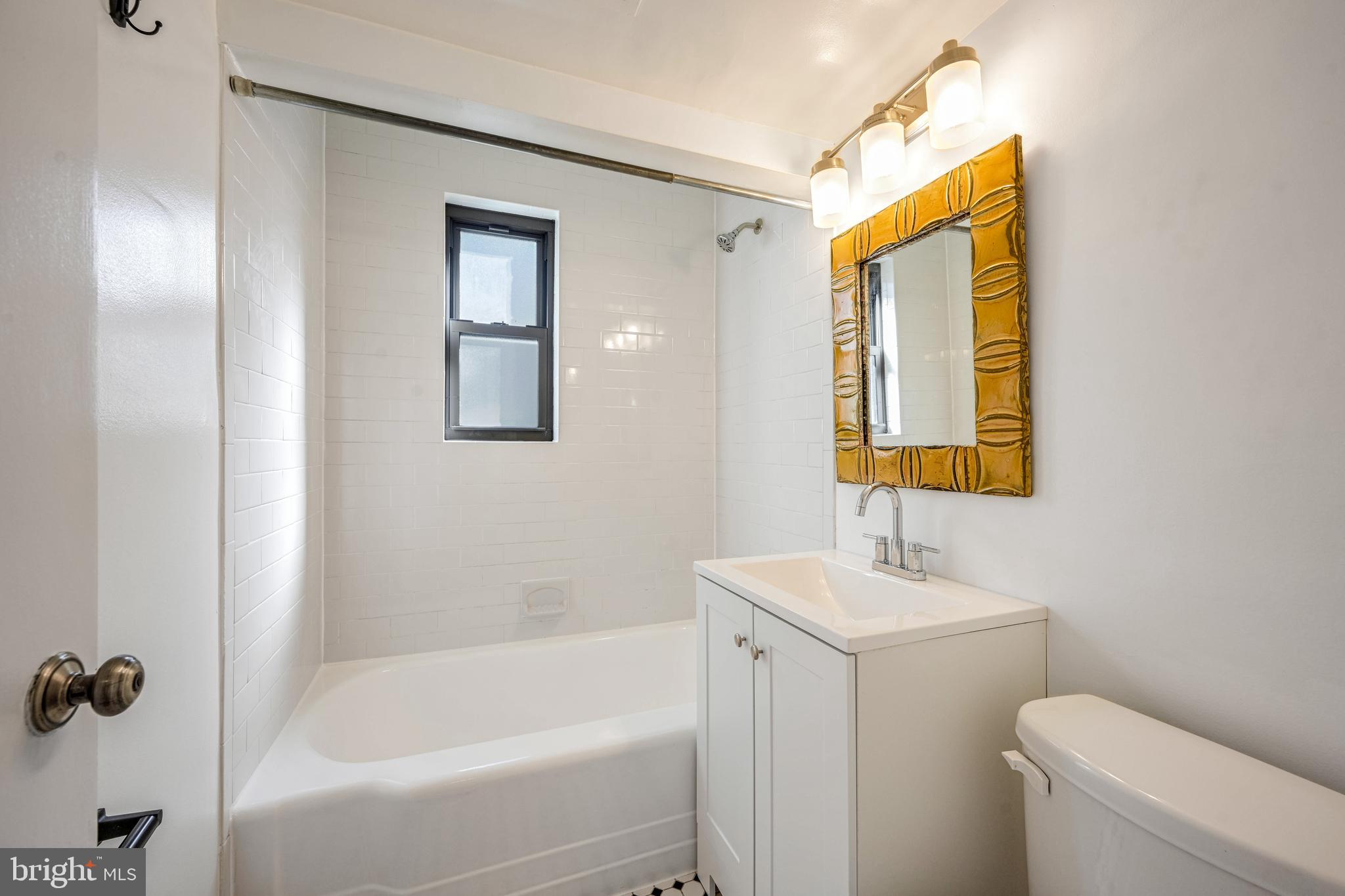 2610 Tunlaw Road Northwest, Unit 104 Washington, DC 20007 - Photo 17 of 20 a bathroom with a sink mirror vanity and toilet