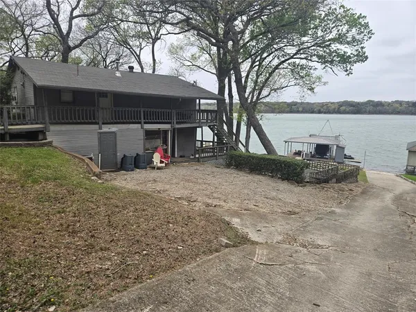 a view of a house with backyard and trees