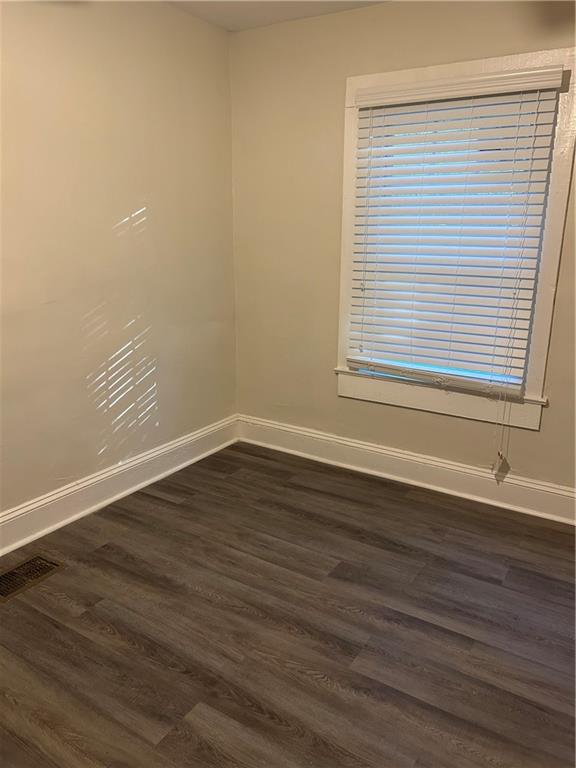 180 Harlan Road Southwest Atlanta, GA 30311 - Photo 11 of 20 a view of an empty room with wooden floor and a window