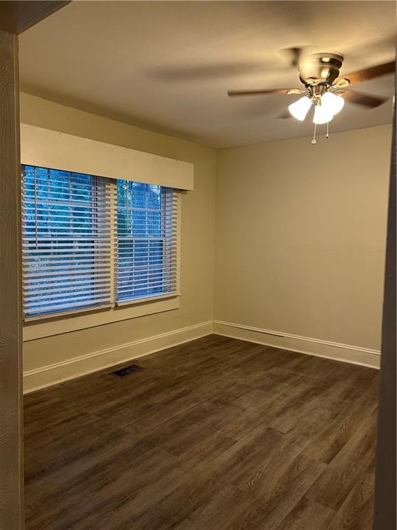 180 Harlan Road Southwest Atlanta, GA 30311 - Photo 12 of 20 a view of an empty room with wooden floor and a window