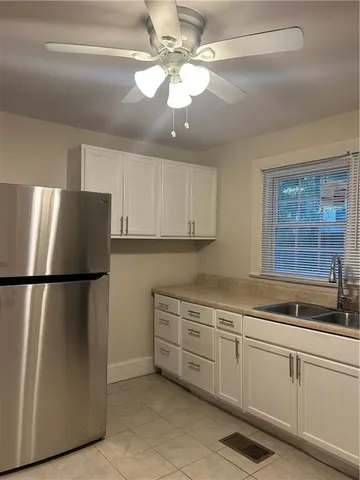 a kitchen with white cabinets and white appliances