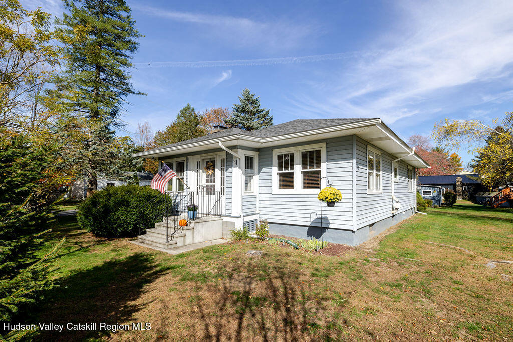 a front view of a house with a yard and potted plants