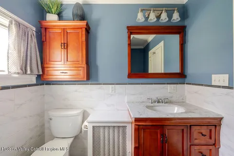 a bathroom with a sink a toilet and mirror
