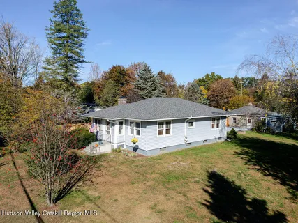 a view of a large house with a big yard and large tree
