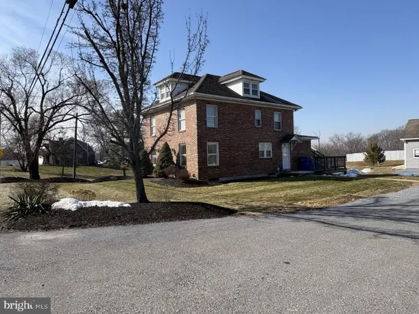 a view of a house with a yard and large tree