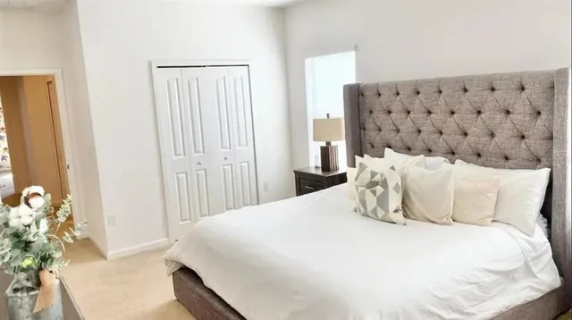 a bed room with a bed and a painting on the wall