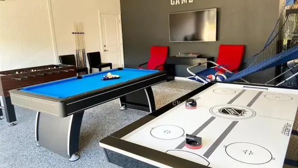 a room with furniture pool table and flat screen tv