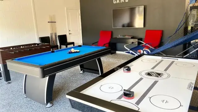 a room with furniture pool table and flat screen tv