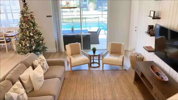 a living room with furniture a large window and a potted plant