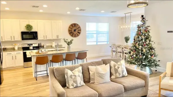 a living room with furniture a large window and a kitchen