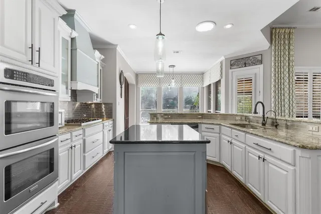 a kitchen with stainless steel appliances granite countertop a sink and stove top oven