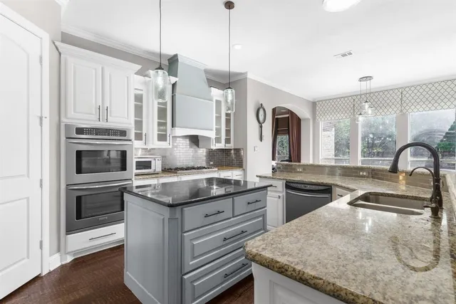 a kitchen with granite countertop a sink stove and cabinets