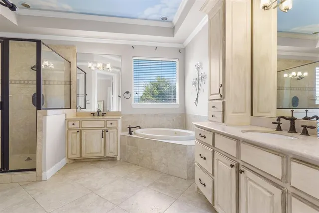 a bathroom with a granite countertop sink mirror bathtub and next to a window