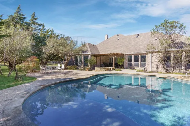 a view of a white house with a swimming pool and a yard
