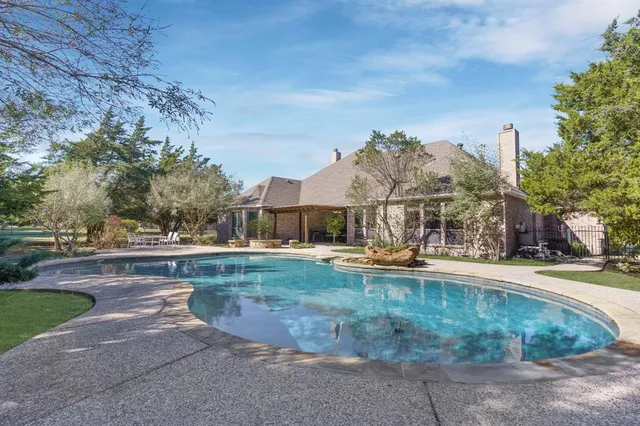 a view of a house with pool and a yard