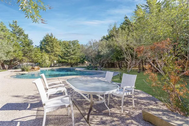 a backyard of a house with table and chairs
