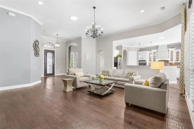 a living room with furniture or chandelier and a wooden floor