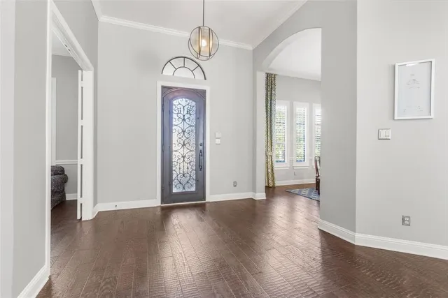 an empty room with wooden floor mirror and windows