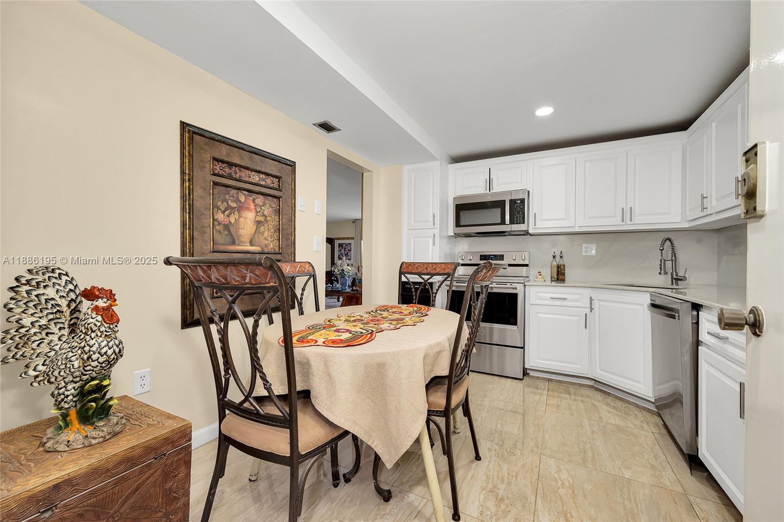 2750 Northeast 183rd Street, Unit 2204 Aventura, FL 33160 - Photo 16 of 31 a kitchen with stainless steel appliances granite countertop a stove top oven a sink a refrigerator with a dining table and chairs