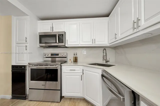 a kitchen with cabinets stainless steel appliances and sink