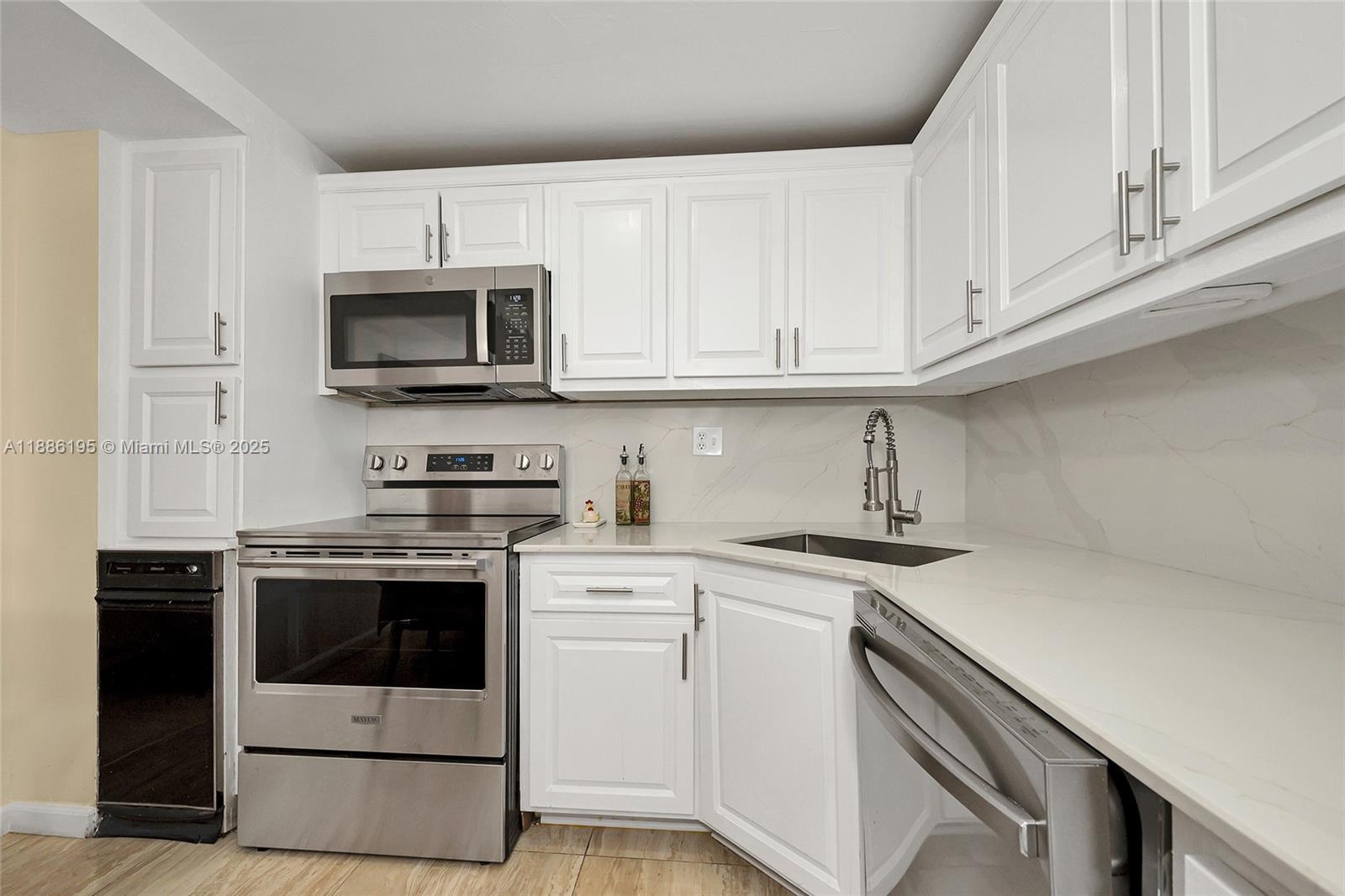 2750 Northeast 183rd Street, Unit 2204 Aventura, FL 33160 - Photo 17 of 31 a kitchen with cabinets stainless steel appliances and sink