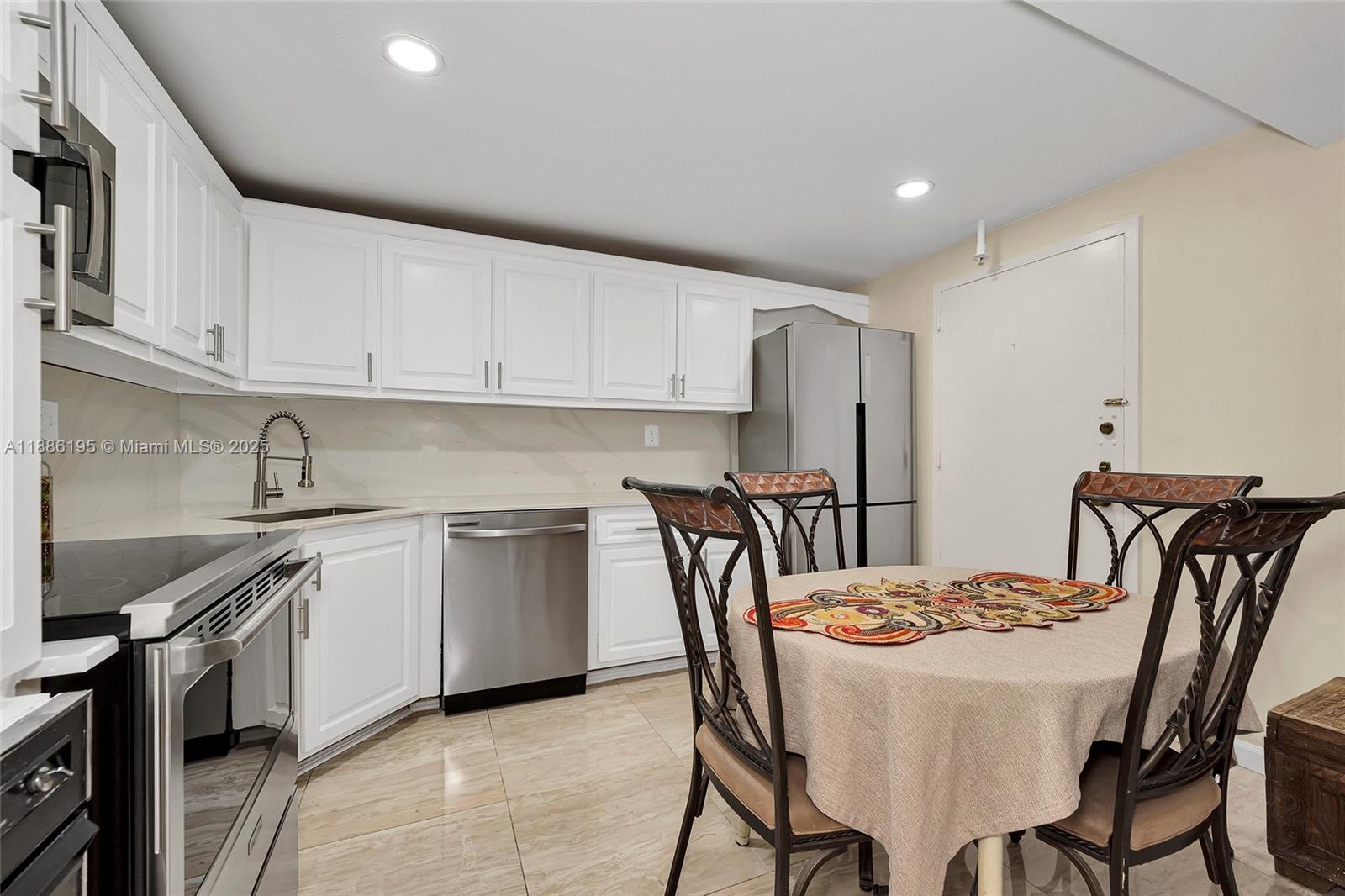 2750 Northeast 183rd Street, Unit 2204 Aventura, FL 33160 - Photo 19 of 31 a kitchen with stainless steel appliances granite countertop a kitchen island a stove a table and chairs