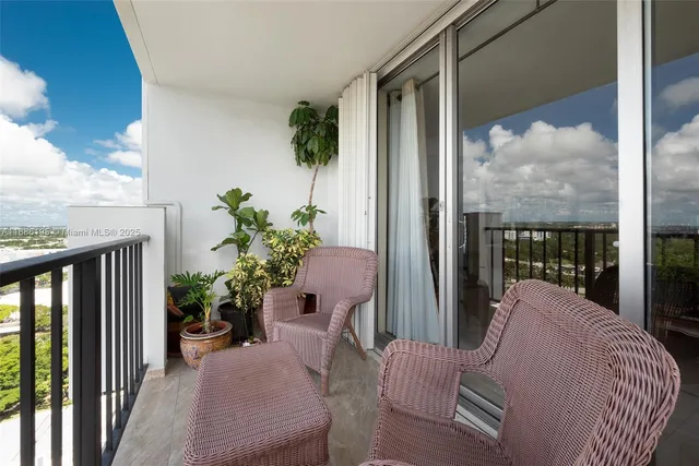 a balcony with furniture and a potted plant