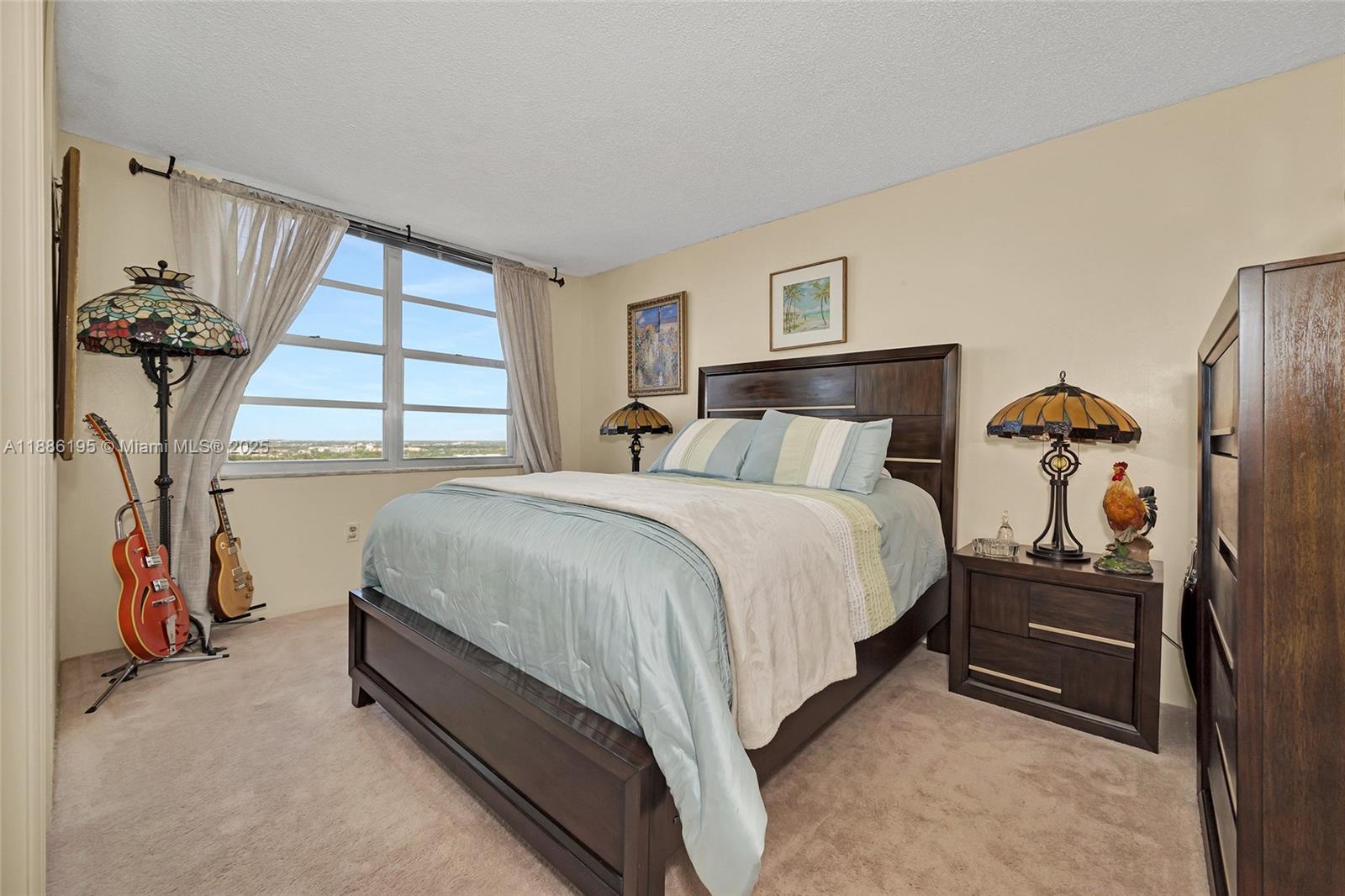 2750 Northeast 183rd Street, Unit 2204 Aventura, FL 33160 - Photo 9 of 31 a spacious bedroom with a bed and a chandelier