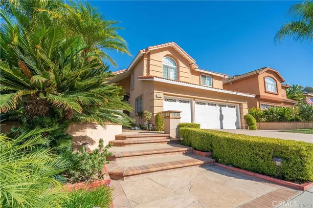 a front view of a house with a yard and potted plants