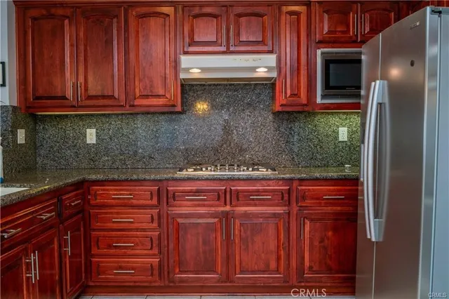 a kitchen with stainless steel appliances granite countertop cabinets and wooden floor