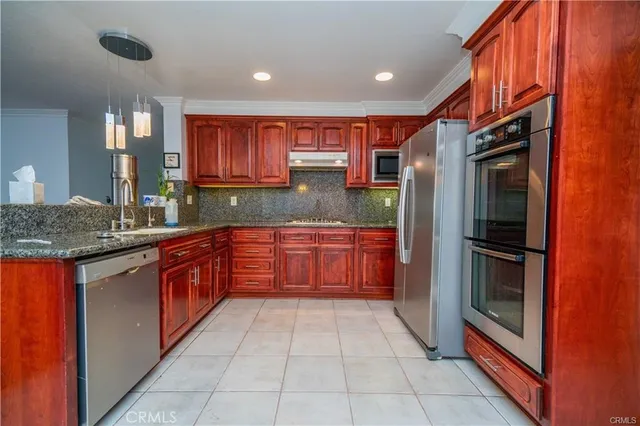 a kitchen with stainless steel appliances granite countertop a refrigerator and a sink