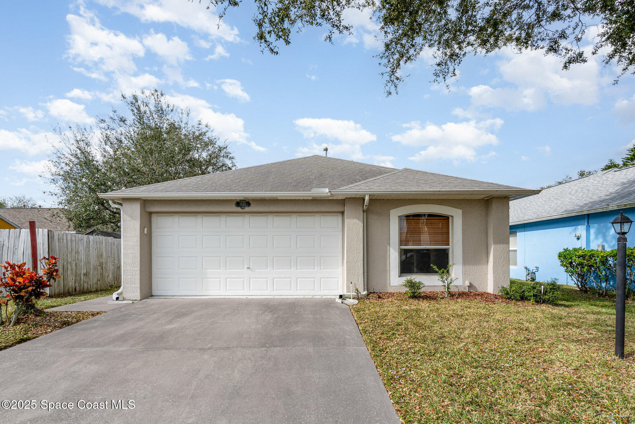 2885 Maderia Circle Melbourne, FL 32935 - Photo 1 of 15 a front view of a house with a yard and garage