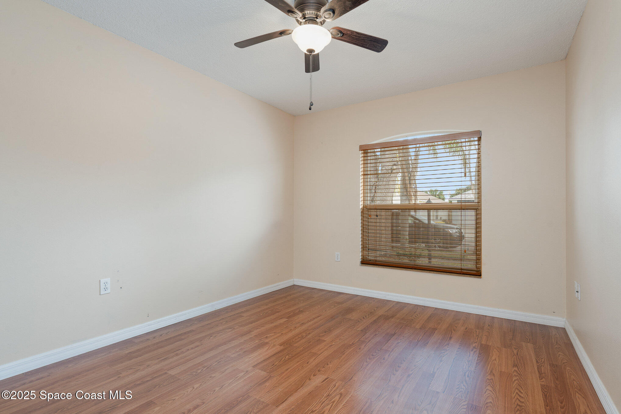 2885 Maderia Circle Melbourne, FL 32935 - Photo 11 of 15 an empty room with wooden floor chandelier and windows