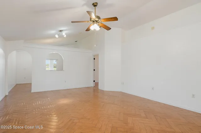 an empty room with a ceiling fan and window
