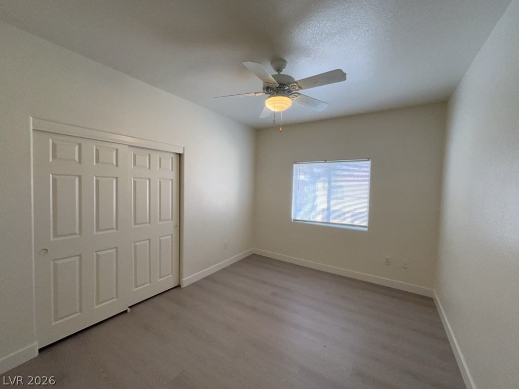 4915 East Russell Road, Unit 147 Las Vegas, NV 89120 - Photo 11 of 14 Unfurnished bedroom featuring wood finished floors, a closet, and a ceiling fan