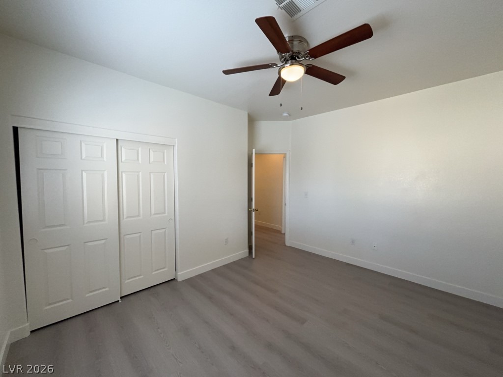 4915 East Russell Road, Unit 147 Las Vegas, NV 89120 - Photo 12 of 14 Unfurnished bedroom featuring ceiling fan, dark wood finished floors, and a closet